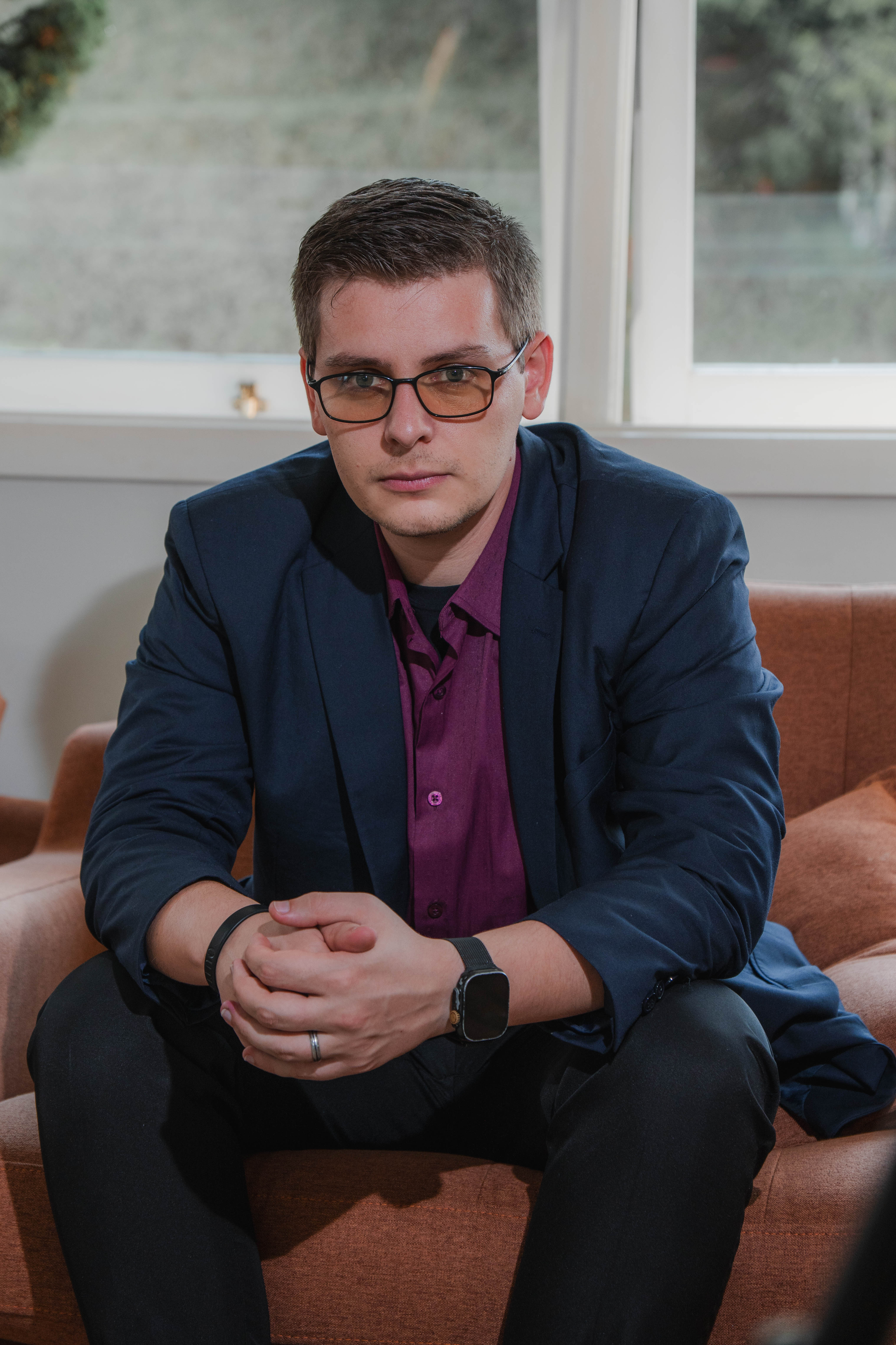 Giovane Carlos - Pose executiva sentado, blazer e camisa roxa, m&atilde;os juntas